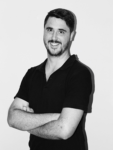 a black-and-white photo of a male with arms crossed