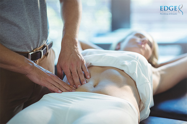 osteopath engaging in visceral manipulation therapy